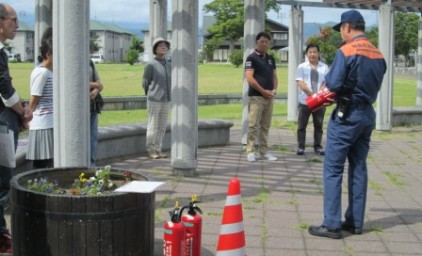 公園にて、消防署員による消火器使用方法の説明
